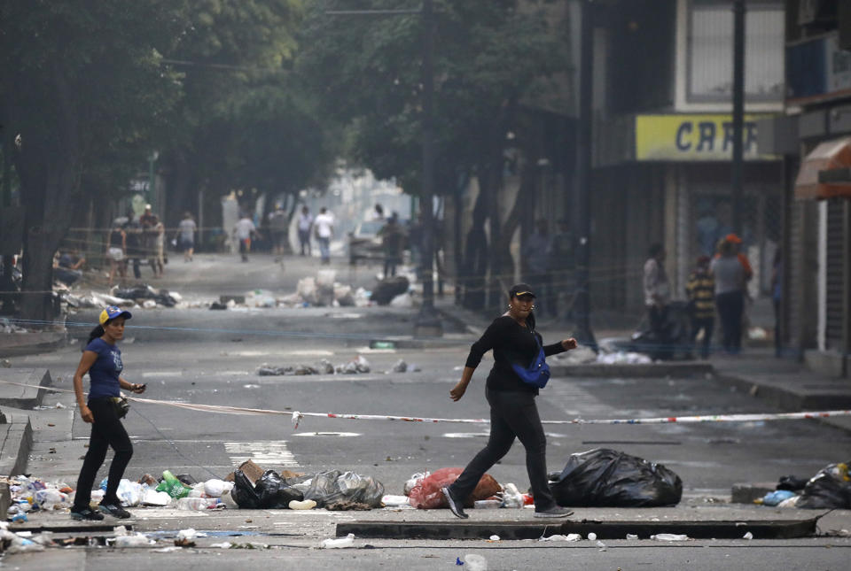 <p>Women cross a rubble-strewn street after clashes broke out while the Constituent Assembly election was being carried out in Caracas, Venezuela, July 30, 2017. (Carlos Garcia Rawlins/Reuters) </p>