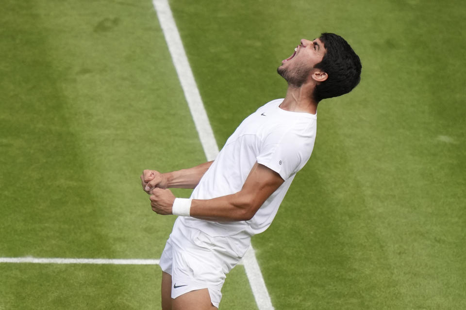 Spain's Carlos Alcaraz celebrates after beating Denmark's Holger Rune to win their men's singles match on day ten of the Wimbledon tennis championships in London, Wednesday, July 12, 2023. (AP Photo/Alberto Pezzali)