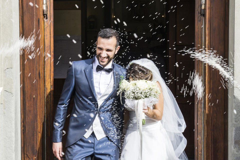 Rice is thrown at a bride and groom as they exit a church