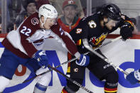 Colorado Avalanche's Fredrik Olofsson, left, and Calgary Flames' Rasmus Andersson work along the boards during the third period of an NHL hockey game Tuesday, March 12, 2024, in Calgary, Alberta. (Larry MacDougal/The Canadian Press via AP)