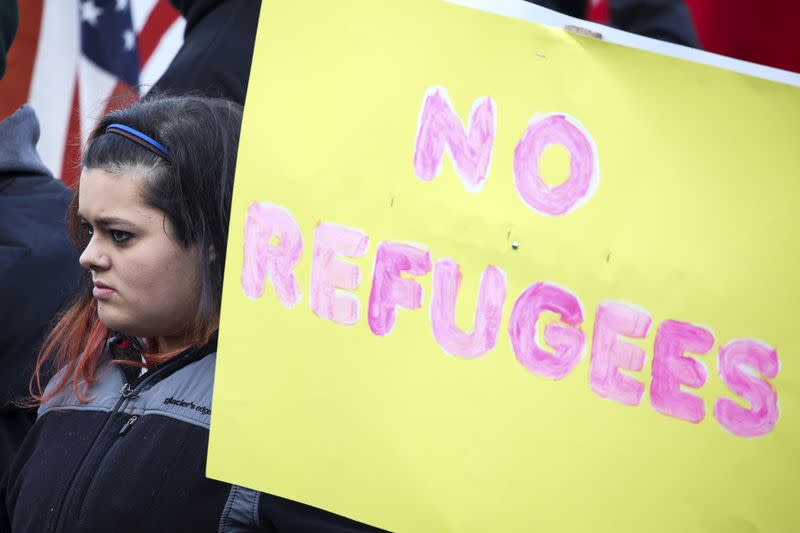 FILE PHOTO: A protestor holds an anti-refugee sign to protest the United States' acceptance of Syrian refugees at the Washington State capitol in Olympia