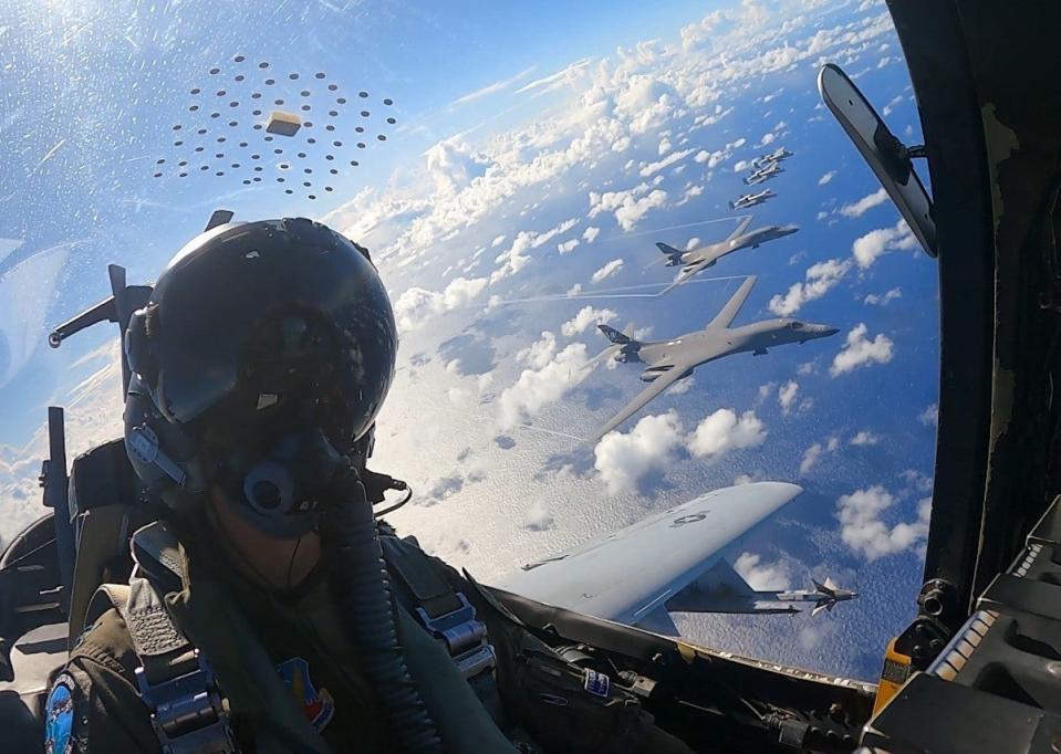 Air Force A-10 Warthog ground attack jets and B-1 bombers fly in formation over the Pacific during an exercise in 2022. <em>USAF</em>