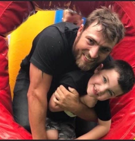 Russell Penley poses with his son for a photo in an inflatable playhouse. Penley, who worked as a surveyor for United Infrastructure Group, died in a construction accident along I-26 on Aug. 17.