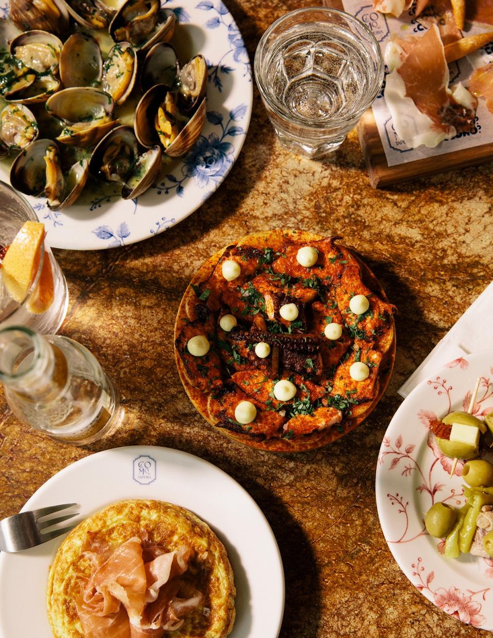 <cite class="credit"><em>Photo by Grant Harder</em> | Clams in vermut, jamon serrano gran reserva 24 months, stuffed olives and gildas, tortilla con jamon, malaca G&T, galician octopus at Cómo Taperia</cite>