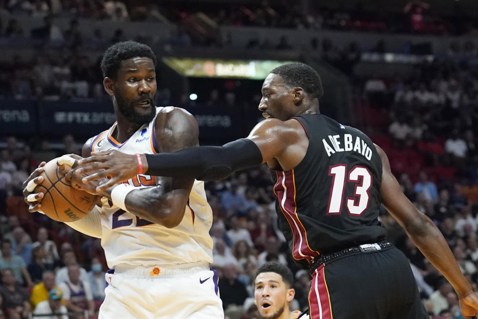 Phoenix Suns center Deandre Ayton (22) grabs a rebound as Miami Heat center Bam Adebayo (13) defends during the first half of an NBA basketball game Monday, Nov. 14, 2022, in Miami. (AP Photo/Marta Lavandier)