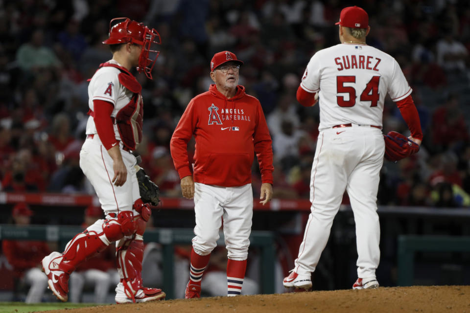 Los Angeles Angels manager Joe Maddon, center, walks to the mound to remove starting pitcher Jose Suarez, right, during the sixth inning of the team's baseball game against the Oakland Athletics in Anaheim, Calif., Saturday, Sept. 18, 2021. At left is catcher Max Stassi. (AP Photo/Alex Gallardo)