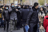 Zhou Xiaoxuan, right, looks as Chinese policemen block a foreign journalist on her arrival at a courthouse in Beijing, Wednesday, Dec. 2, 2020. Zhou, a Chinese woman who filed a sexual harassment lawsuit against a TV host, told cheering supporters at a courthouse Wednesday she hopes her case encourages other "victims of gender violence" in a system that gives them few options to pursue complaints.(AP Photo/Andy Wong)