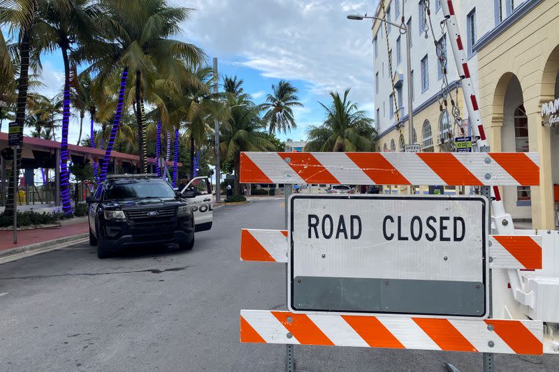 A barrier blocks a street prior to the 8 pm curfew in Miami Beach