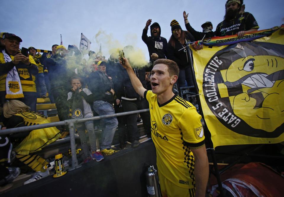 Wil Trapp lights a smoke flare with fans in the Nordecke following the first leg of the MLS Cup Eastern Conference semifinal at Mapfre Stadium on Nov. 4, 2018. [Adam Cairns/Dispatch]