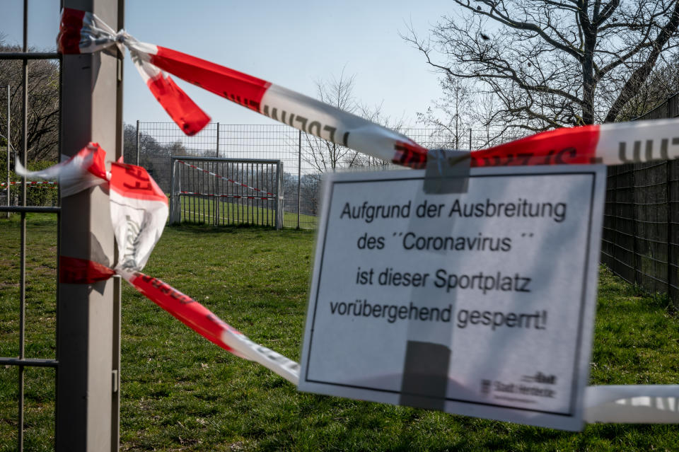 ARCHIV - 28.03.2020, Nordrhein-Westfalen, Herdecke: Ein Sportplatz ist bei Sonnenschein und milden Temperaturen Aufgrund der Ausbreitung des Coronavirus vorübergehend gesperrt. Nordrhein-Westfalen nimmt weiter Kurs auf Normalität. Vom 15.06.2020 an werden weitere Corona-Schutzmaßnahmen im bevölkerungsreichsten Bundesland gelockert. Im Freien wird Kontaktsport wie Fußball in Gruppen bis zu 30 Personen erlaubt.     (zu dpa «NRW lockert weiter: Bier in der Bar, Kickern mit der Mannschaft») Foto: Bernd Thissen/dpa +++ dpa-Bildfunk +++