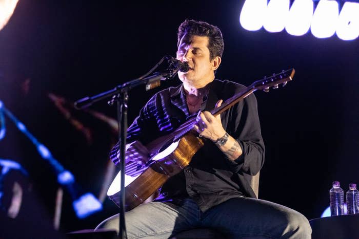 John Mayer playing guitar on stage