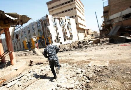 Iraqi Federal Police take cover during a battle with Islamic State fighters at Bab al Jadid district in the old city of Mosul, Iraq, March 26, 2017. REUTERS/Youssef Boudlal