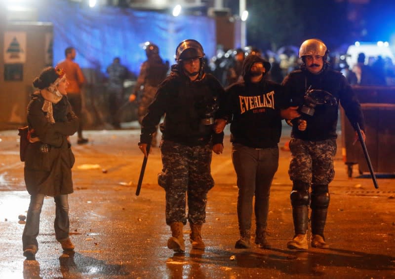 Riot police restrain a protestor during a protest against a ruling elite accused of steering Lebanon towards economic crisis in Beirut