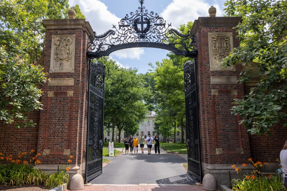 People walk through the gate on Harvard Yard at Harvard University.