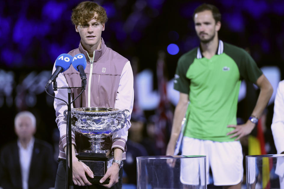 Jannik Sinner, left, of Italy holds the Norman Brookes Challenge Cup as he speaks to the spectators after defeating Daniil Medvedev of Russia in the men's singles final at the Australian Open tennis championships at Melbourne Park, in Melbourne, Australia, Sunday, Jan. 28, 2024. (AP Photo/Asanka Brendon Ratnayake)