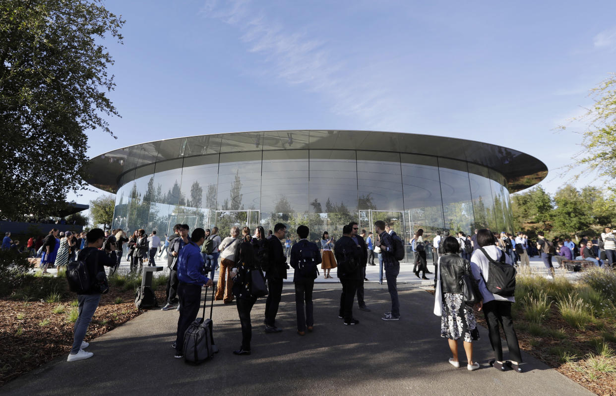 File - People stand outside of the Steve Jobs Theater before an event on Wednesday, Sept. 12, 2018, in Cupertino, Calif. If Apple unveils a widely anticipated headset equipped with mixed reality technology at the theater on Monday, it will be the company's biggest new product since the introduction of the Apple Watch nearly a decade ago.(AP Photo/Marcio Jose Sanchez, File)