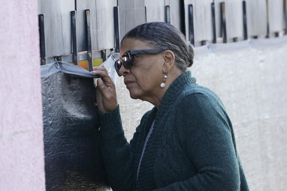 FILE - Tanya Britton, a former president of Pro-Life Mississippi, peers through a barrier around Mississippi's only abortion clinic on Nov. 30, 2021, in Jackson, Miss. Britton often travels from her home in Tupelo, Miss., to pray outside the clinic and to try to persuade women not to go inside to end their pregnancies. Britton says it's a tragedy that the number of Black babies aborted since the Supreme Court's 1973 Roe v. Wade decision would equal the population of several large cities. She also says people are too casual about terminating pregnancies. (AP Photo/Rogelio V. Solis, File)