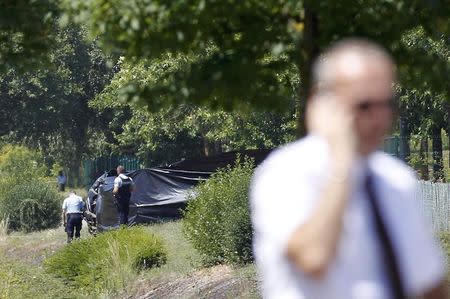 French Gendarmes stand guard next to a black plastic sheet outside a gas company site at the industrial area of Saint-Quentin-Fallavier, near Lyon, France, June 26, 2015. REUTERS/Emmanuel Foudrot