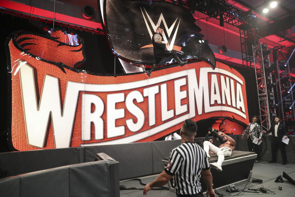 Kevin Owens jumps off a WrestleMania sign on Saturday night.