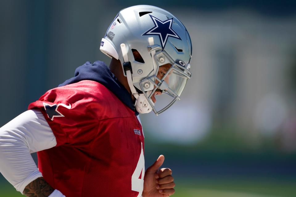 Dallas Cowboys quarterback Dak Prescott jogs onto the practice field for a workout at the team's NFL football training facility in Frisco, Texas, Wednesday, Aug. 25, 2021.