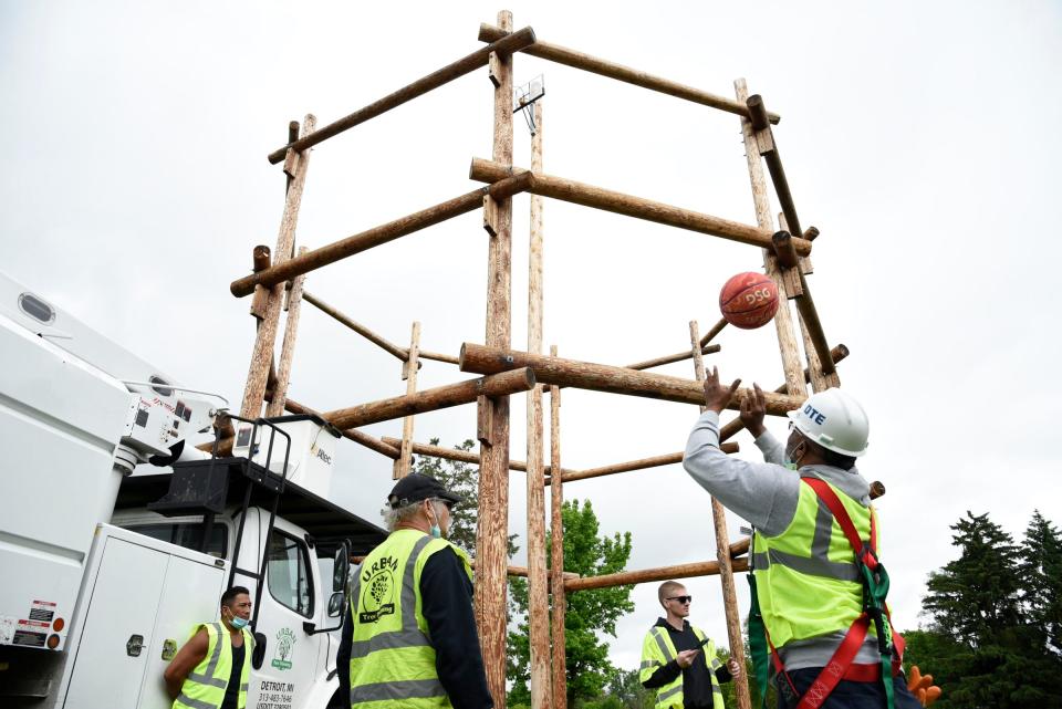 Gerald Nelson, 58, of Southfield, throws the basketball in the air before moving up 80 feet in the truck to shoot the ball into the basket as a part of the training exercise at the DTE Tree Trim Academy in Detroit on Tuesday, June 7, 2022.