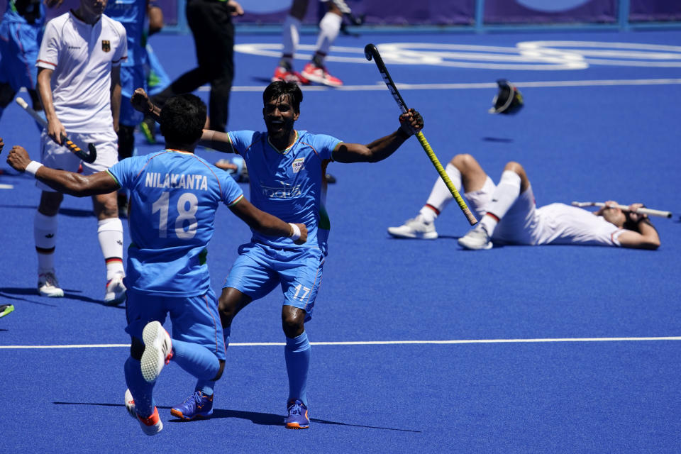 India's Nilakanta Sharma (18) and Sumit (17) celebrate as Germany's Lukas Windfeder, right, reacts after India won their men's field hockey bronze medal match 5-4 at the 2020 Summer Olympics, Thursday, Aug. 5, 2021, in Tokyo, Japan. (AP Photo/John Locher)