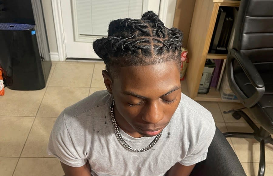 In this photo provided by Darresha George, her son Darryl George, 17, a junior at Barbers Hill High School in Mont Belvieu, Texas, sits for a photo showing his locs, at the family’s home, Sept. 10, 2023. The same week a state law went into effect prohibiting discrimination on the basis of hair, George was suspended because his locs did not comply with the district’s dress code. (Darresha George via AP)