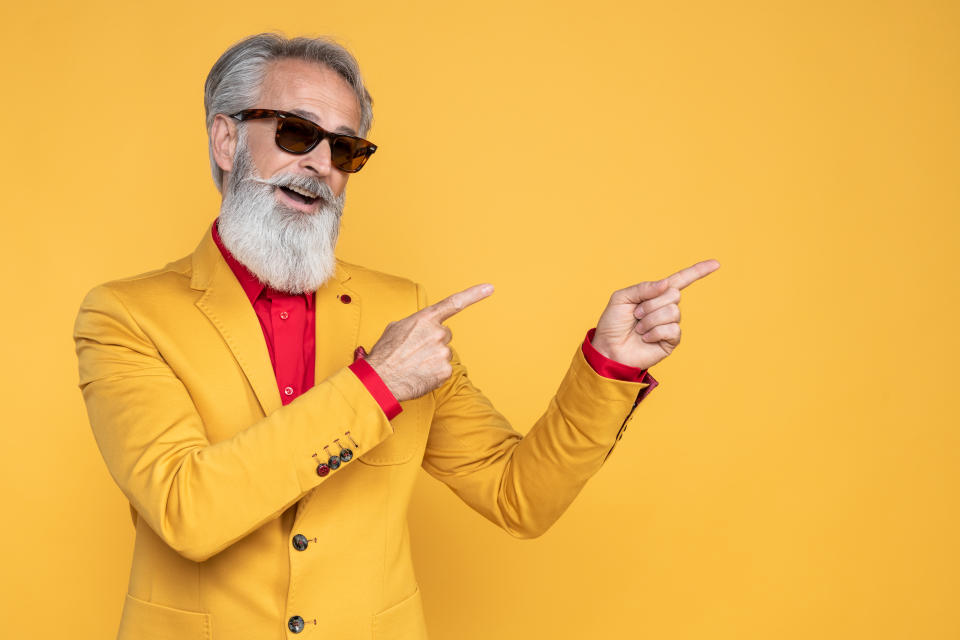 Portrait of senior man wearing yellow jacket on yellow background. 