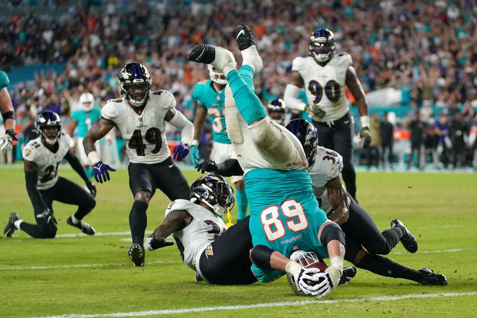 Dolphins guard Rob Hunt is upended while reaching for the end zone against the Ravens.