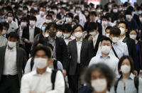 A station passageway is crowded with commuters wearing face mask during a rush hour Tuesday, May 26, 2020, in Tokyo. Japan has kept its deaths from the new coronavirus low despite a series of missteps that beg the question of whether it can prevent future waves of infections. (AP Photo/Eugene Hoshiko, File)