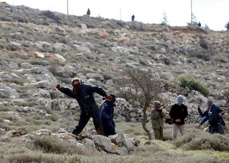 A protestor throws a stone towards Israeli security forces during an eviction of residents from the Israeli settler outpost of Amona in the occupied West Bank February 1, 2017. REUTERS/Baz Ratner