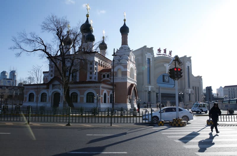 A man runs near an Orthodox church on a cold winter day in Harbin