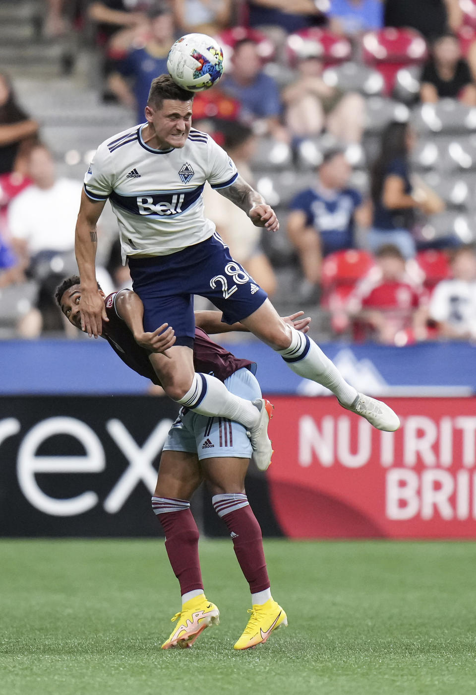 Vancouver Whitecaps' Jake Nerwinski, top, and Colorado Rapids' Jonathan Lewis vie for the ball during the second half of an MLS soccer match Wednesday, Aug. 17, 2022, in Vancouver, British Columbia. (Darryl Dyck/The Canadian Press via AP)