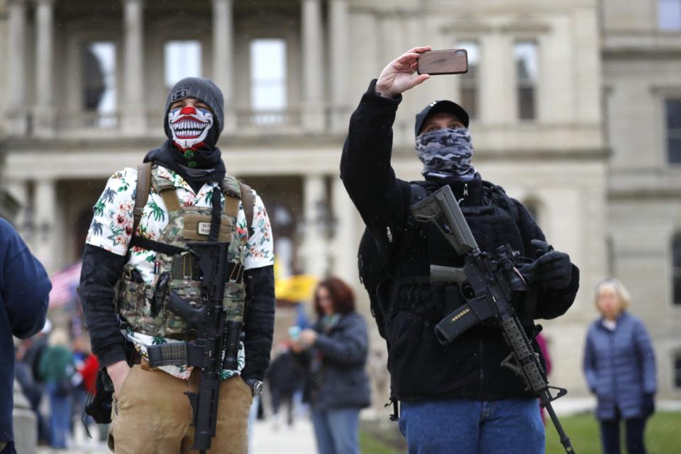 Protesters with rifles stand outside the State Capitol in Lansing, Mich., on April 15.