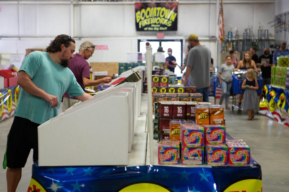 Customers look over rows of pyrotechnics at Boomtown Fireworks, 5005 S.W. Topeka Blvd.