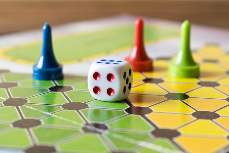 Multi-colored game chips with dice on the playing board. Board game.