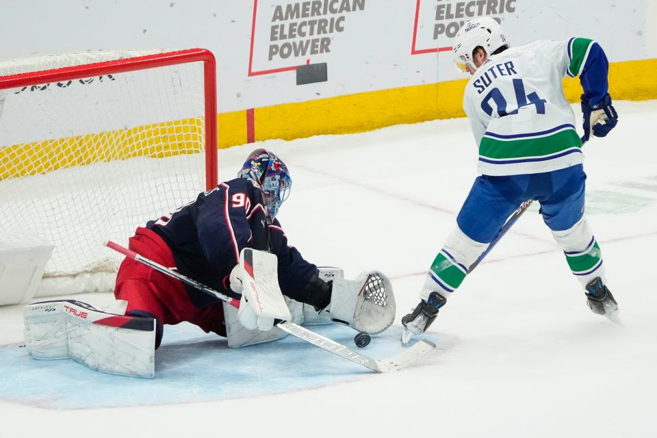 Jan 15, 2024; Columbus, Ohio, USA; Columbus Blue Jackets goaltender Elvis Merzlikins (90) makes the decisive save on Vancouver Canucks center Pius Suter (24) during the shootout in the NHL hockey game at Nationwide Arena. The Blue Jackets won 4-3 in a shootout.