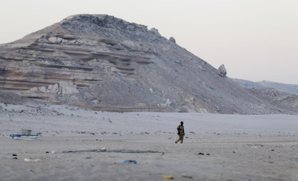 FILE - In this photo taken Monday, March 6, 2017, a Somali government soldier walks on the beach in Eyl, in Somalia's semiautonomous northeastern state of Puntland. Somali pirates have seized a small boat, kidnapped its Indian crew members, and are taking the vessel to the Eyl area of northern Somalia, an investigator said Monday, April 3, 2017, the latest vessel targeted by the region's resurgent hijackers. (AP Photo/Ben Curtis)