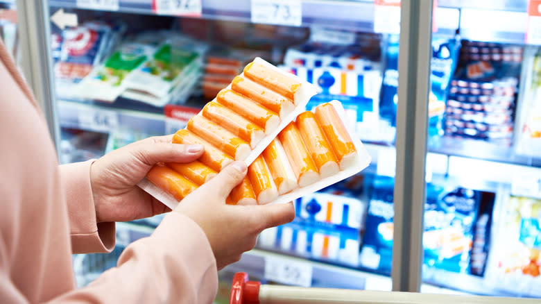 hands holding crab sticks grocery store