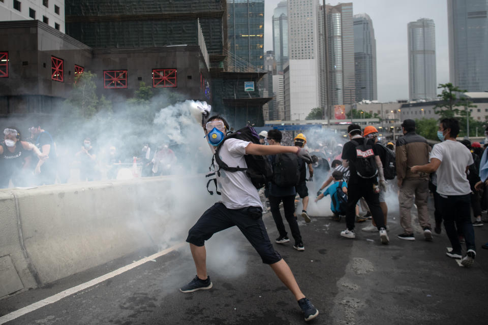 HONG KONG, HONG KONG - JUNE 12:  A Protester throws back the tear gas during a protest against a proposed extradition law on June 12, 2019 in Hong Kong, Hong Kong. Large crowds of protesters gathered in central Hong Kong as the city braced for another mass rally in a show of strength against the government over a divisive plan to allow extraditions to China. (Photo by Billy H.C. Kwok/Getty Images)