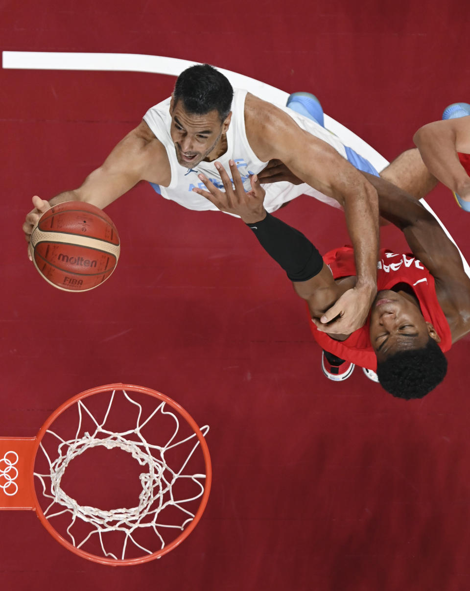 Argentina's Luis Scola, left, drives to the basket against Japan's Rui Hachimura, right, during a men's basketball game at the 2020 Summer Olympics, Wednesday, July 28, 2021, in Saitama, Japan. (Aris Messinis/Pool Photo via AP)