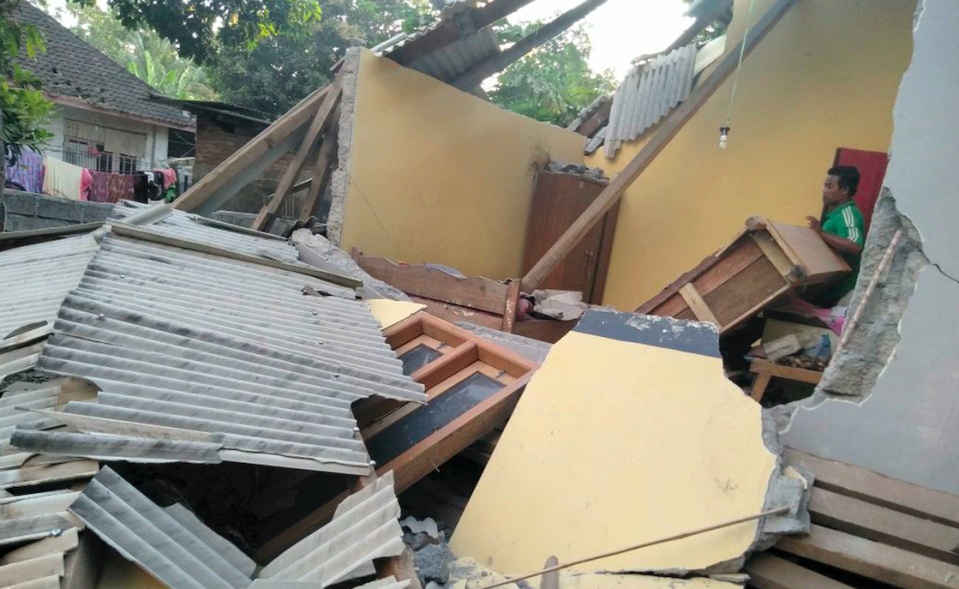 <em>A man inspects the damage caused by the quake (AP)</em>