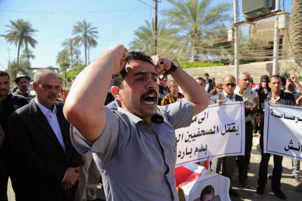 Mourners chant slogans during a symbolic funeral for the bureau chief of a local radio station in Baghdad, Iraq, Sunday, March 23, 2014. A junior officer working for Iraqi President Jalal Talabani, also an ethnic Kurd, shot dead Mohammed Bdaiwi, a well-known radio journalist during a quarrel Saturday near the leader's east Baghdad residence, police said. (AP Photo/Karim Kadim)