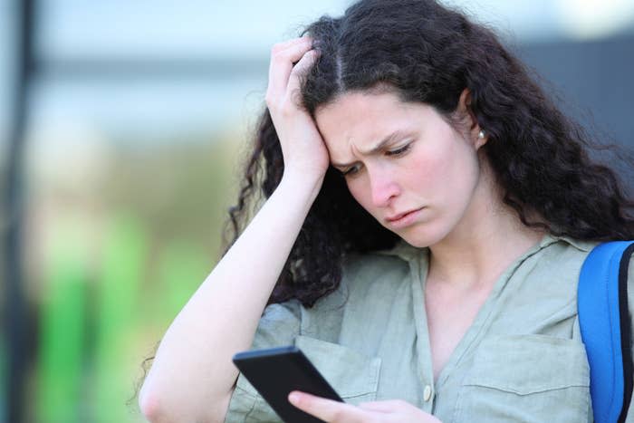 Sad student upset reading message on phone