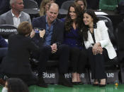 Massachusetts Gov.-Elect Maura Healey takes a photo of Britain's William and Kate, Princess of Wales, and Emilia Fazzalari, wife of Boston Celtics owner Wyc Grousbeck during a timeout in an NBA basketball game between the Boston Celtics and the Miami Heat in Boston, Wednesday, Nov. 30, 2022. (Jim Davis/The Boston Globe vai AP, Pool)