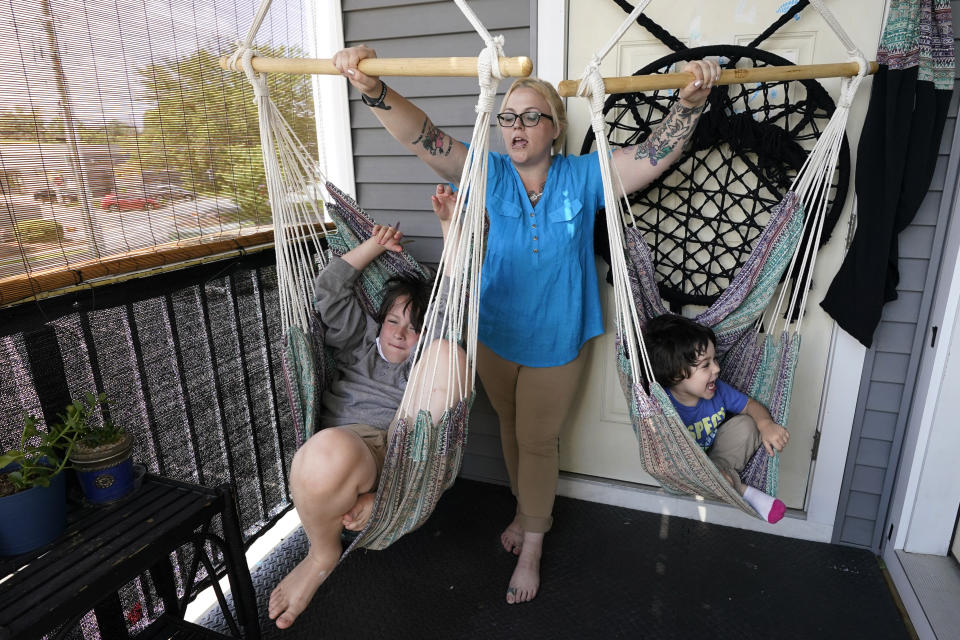 In this July 28, 2021 photo, Christina Darling plays with her sons Kayden, 10, left, and Brennan, 4, at home in Nashua, N.H. Darling and her family have qualified for the expanded child tax credit, part of President Joe Biden's $1.9 trillion coronavirus relief package. "Every step closer we get to a livable wage is beneficial. That is money that gets turned around and spent on the betterment of my kids and myself," said Darling, a housing resource coordinator who had been supplementing her $35,000-a-year salary with monthly visits to the Nashua Soup Kitchen and Shelter's food pantry. (AP Photo/Elise Amendola)