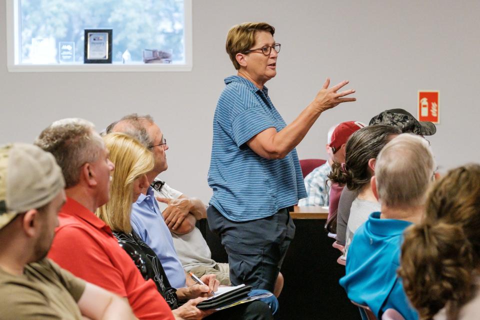 Jill Lengler, former floodplain coordinator for Tuscarawas County, asks questions of Bill Gibson, a developer with Lawver Homes, during a public hearing on plans to create an incentive district to pay for infrastructure at a proposed housing development.
