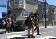 <p>UPS workers are escorted by San Francisco police at the scene of a shooting at a UPS facility on June 14, 2017 in San Francisco, California. (Justin Sullivan/Getty Images) </p>