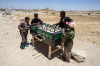 <p>Khamir IDP Settlement, Amran Governorate, Yemen, April 14, 2017: Displaced children play on a donated foosball table in the Khamir IDP settlement, some 80 km north of the Yemeni capital of Sana’a. (Photograph by Giles Clarke for UN OCHA/Getty Images) </p>