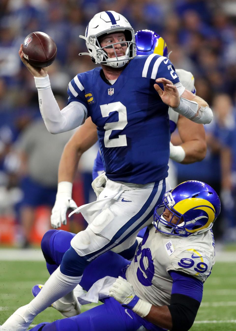 Indianapolis Colts quarterback Carson Wentz (2) tries to pass as he's brought down by Los Angeles Rams defensive end Aaron Donald (99) on Sunday, Sept. 19, 2021, during a game against the Los Angeles Rams at Lucas Oil Stadium in Indianapolis.